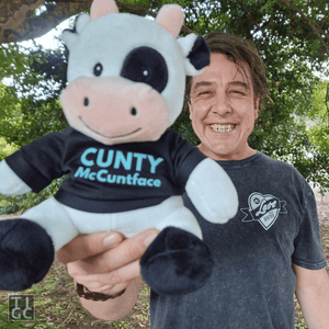 TIGC The Inappropriate Gift Co Cunty McCuntface Cow front view with adult smiling funny stuffed animal